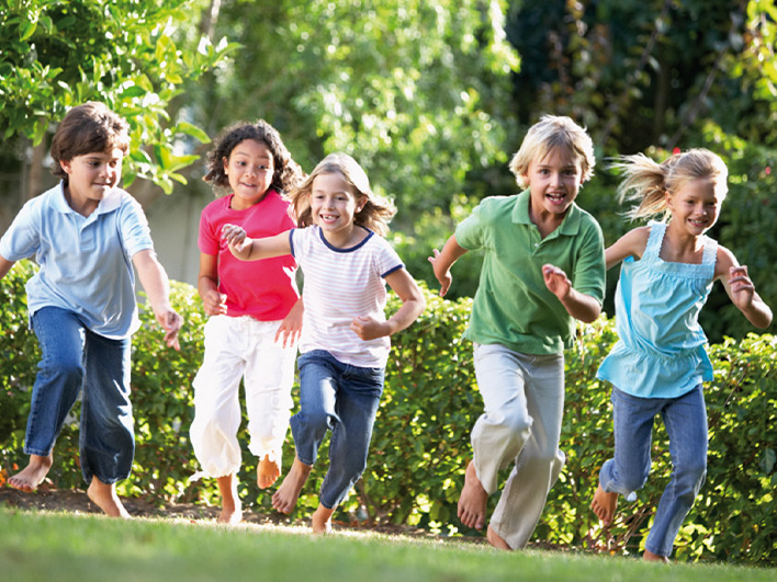 Children barefoot running on grass